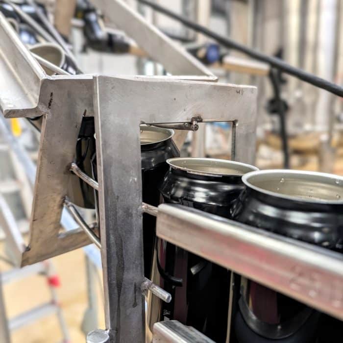 Black cans on a canning line.